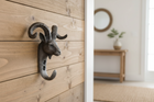 Decorative wall hook shaped like a ram's head with curved horns on a white background